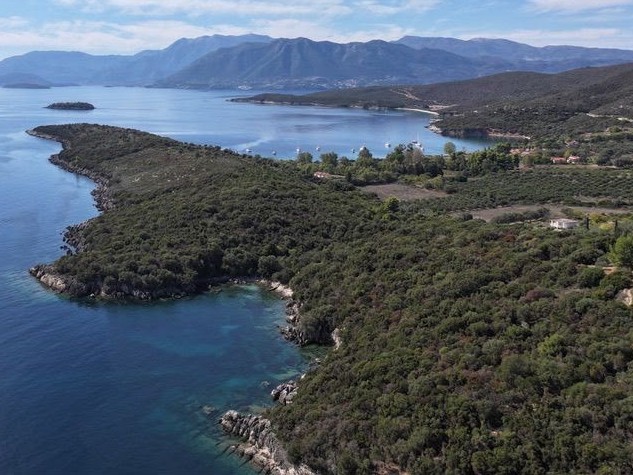 Aerial view of Varko Bay with a green headland, small boats moored in the bay and distant islands