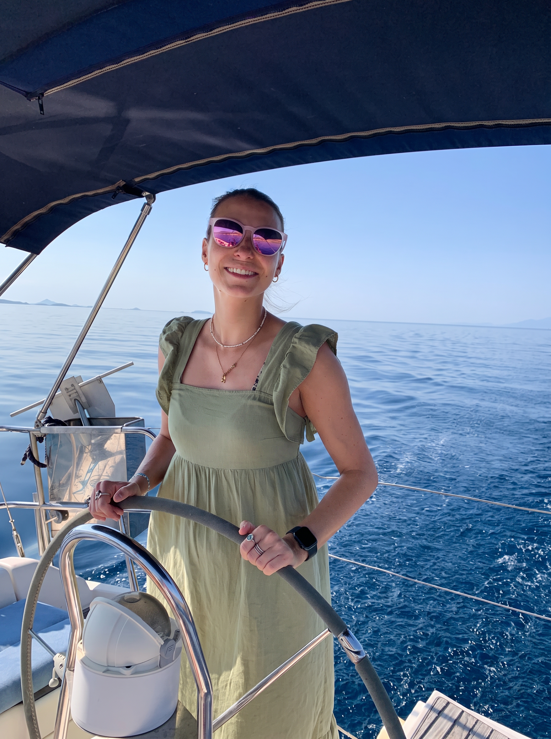 Holly, HOVA Property Management, at the helm of a sailing boat near Paleros